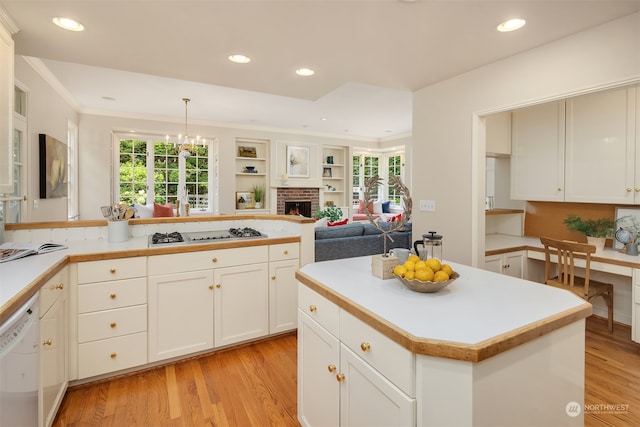 kitchen with pendant lighting, plenty of natural light, white appliances, and light wood-type flooring