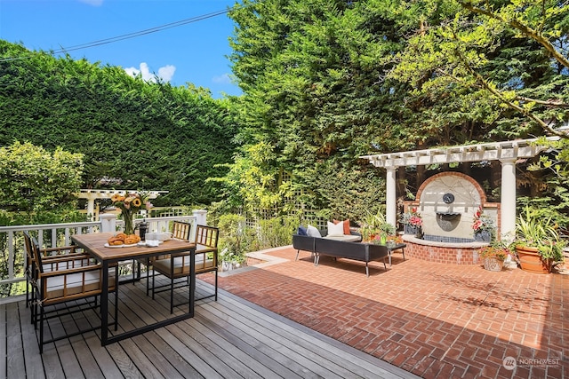 wooden deck featuring exterior fireplace and a patio area