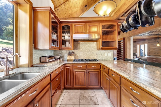 kitchen with light stone countertops, sink, wooden ceiling, stainless steel gas stovetop, and decorative backsplash