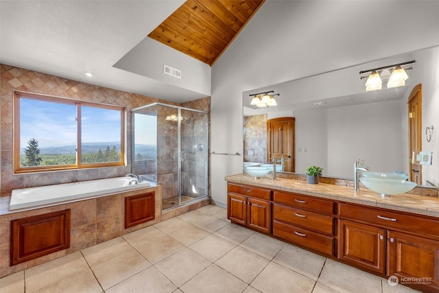 bathroom with vanity, lofted ceiling, separate shower and tub, and tile patterned flooring