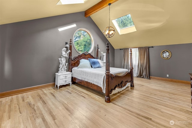 bedroom featuring a notable chandelier, lofted ceiling with skylight, and hardwood / wood-style flooring