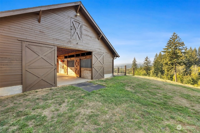 back of house featuring a yard and an outdoor structure