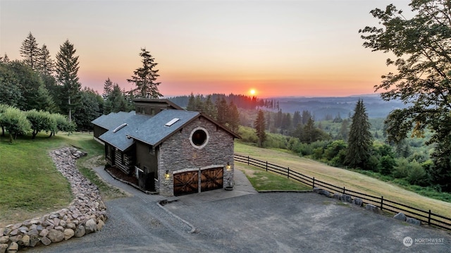 property exterior at dusk with a rural view and a yard