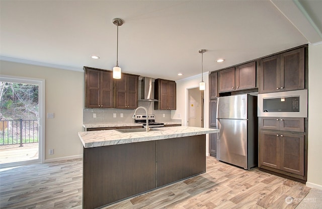 kitchen with light wood-type flooring, wall chimney exhaust hood, dark brown cabinetry, stainless steel appliances, and crown molding