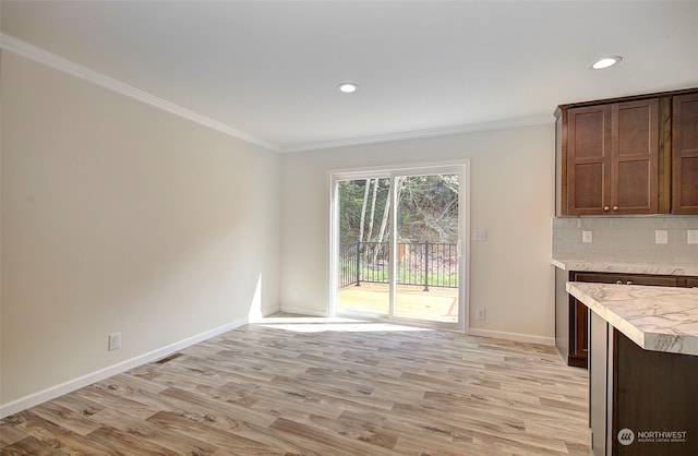 unfurnished dining area with ornamental molding and light hardwood / wood-style flooring