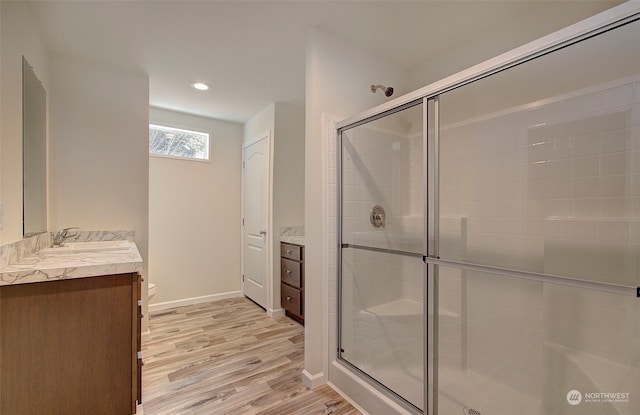 bathroom with vanity, an enclosed shower, and wood-type flooring