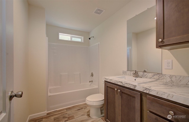 full bathroom featuring hardwood / wood-style floors, vanity, shower / bathtub combination, and toilet