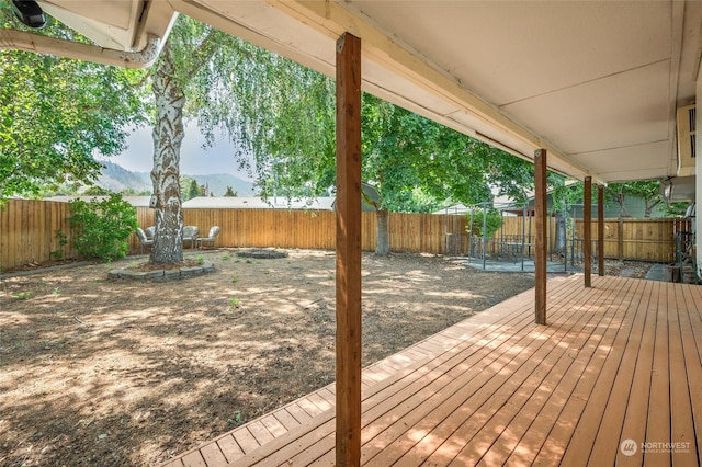wooden terrace with a fenced backyard and a mountain view