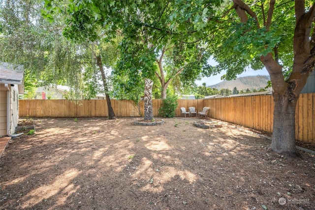 view of yard featuring a mountain view and a fenced backyard
