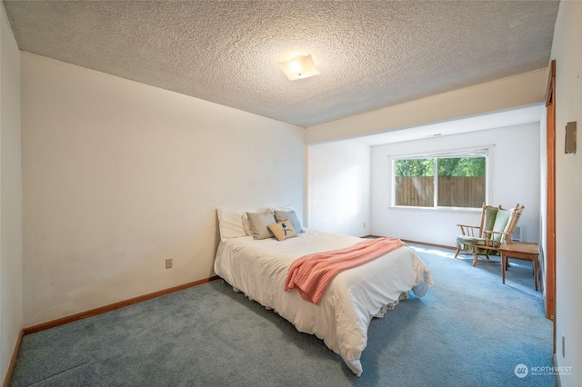 bedroom featuring carpet floors, baseboards, and a textured ceiling