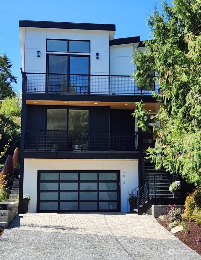 contemporary home featuring a garage and a balcony