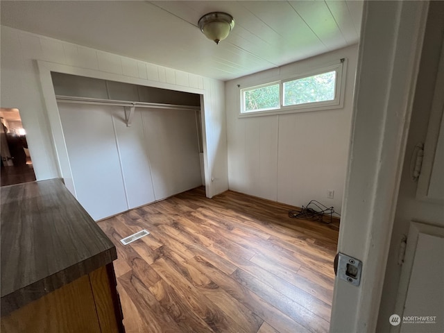 unfurnished bedroom with a closet and hardwood / wood-style floors