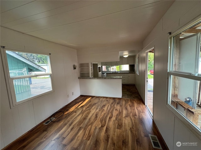 unfurnished living room with dark wood-type flooring