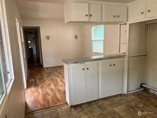 kitchen with dark wood-type flooring and white cabinetry