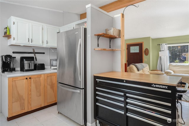 kitchen featuring light tile patterned floors, freestanding refrigerator, light countertops, white cabinetry, and open shelves