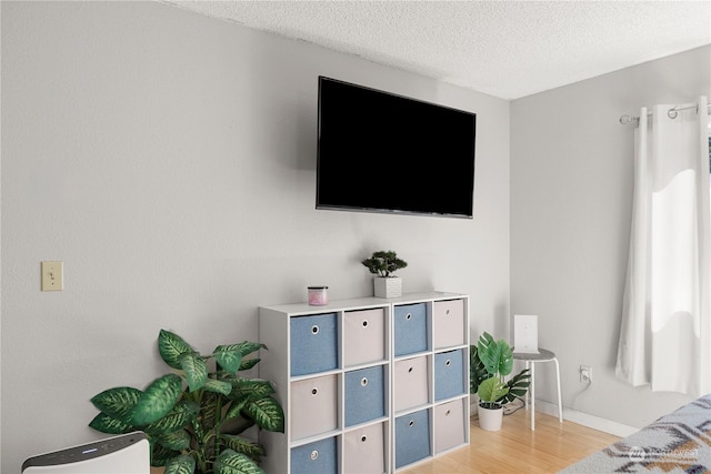 interior space with light wood-style floors, baseboards, and a textured ceiling