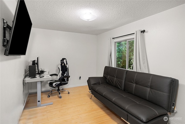 office space with a textured ceiling, baseboards, and wood finished floors