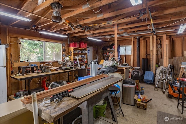 miscellaneous room featuring unfinished concrete flooring and a workshop area