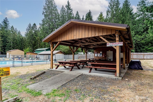 surrounding community featuring a gazebo, a patio area, fence, and a swimming pool