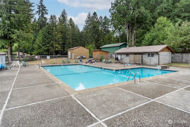 pool with a patio and fence