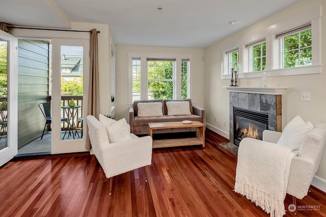 living room featuring a tile fireplace, hardwood / wood-style flooring, and plenty of natural light