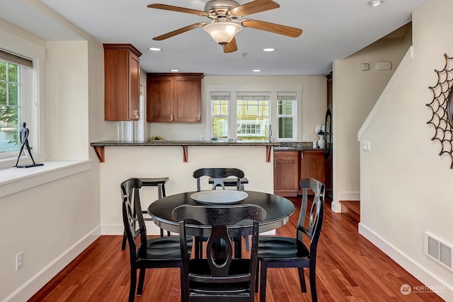 dining area featuring ceiling fan and dark hardwood / wood-style floors