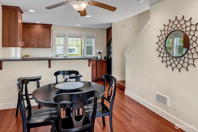 dining space with dark wood-type flooring and ceiling fan