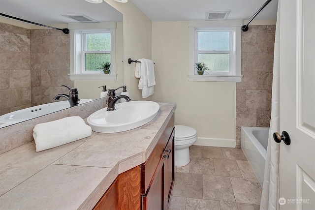 full bathroom with a healthy amount of sunlight, toilet, vanity, and shower / bath combo