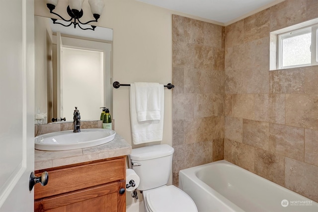 bathroom featuring vanity, toilet, and a washtub