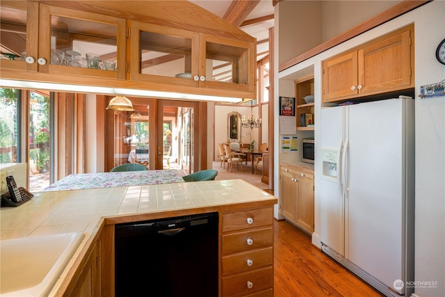 kitchen with brown cabinetry, dishwasher, tile countertops, stainless steel microwave, and white fridge with ice dispenser