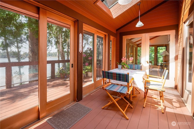 sunroom with lofted ceiling with skylight, a water view, and wooden ceiling