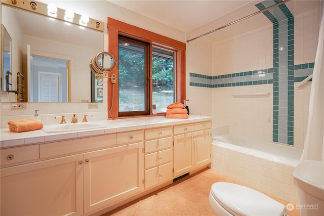 full bath featuring tiled shower / bath combo, vanity, and toilet