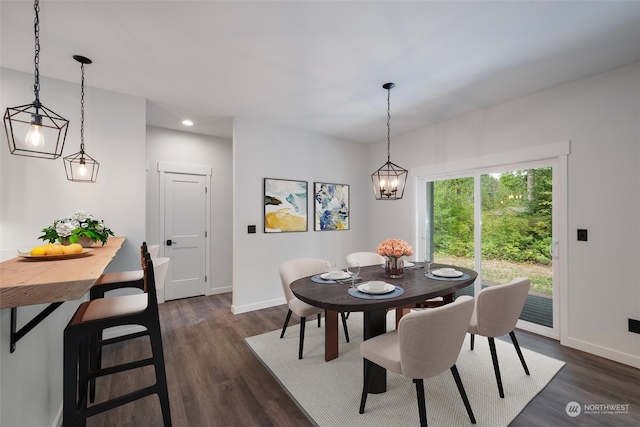 dining space featuring dark hardwood / wood-style floors and an inviting chandelier