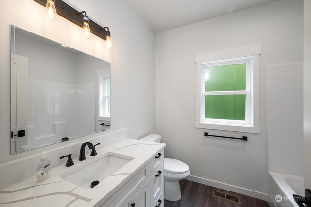 full bathroom featuring vanity, toilet, hardwood / wood-style flooring, and plenty of natural light