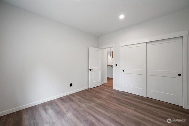 unfurnished bedroom with hardwood / wood-style floors and a closet