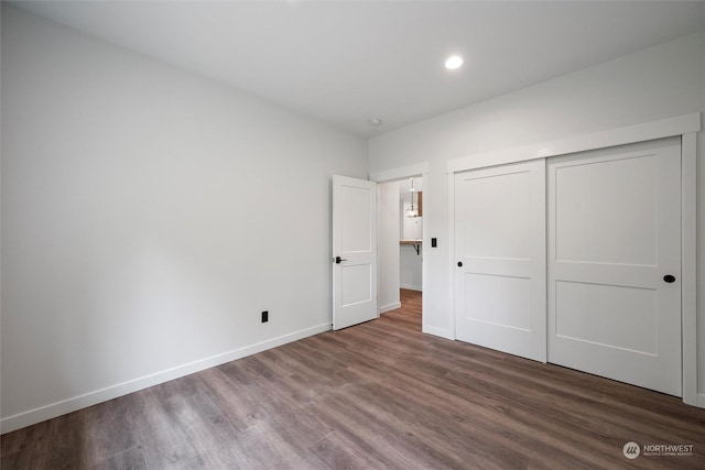 unfurnished bedroom featuring hardwood / wood-style floors and a closet