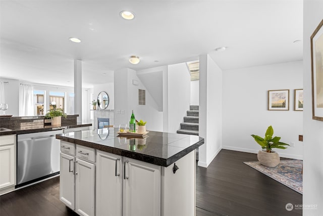 kitchen with dark hardwood / wood-style floors, a center island, dishwasher, and white cabinetry