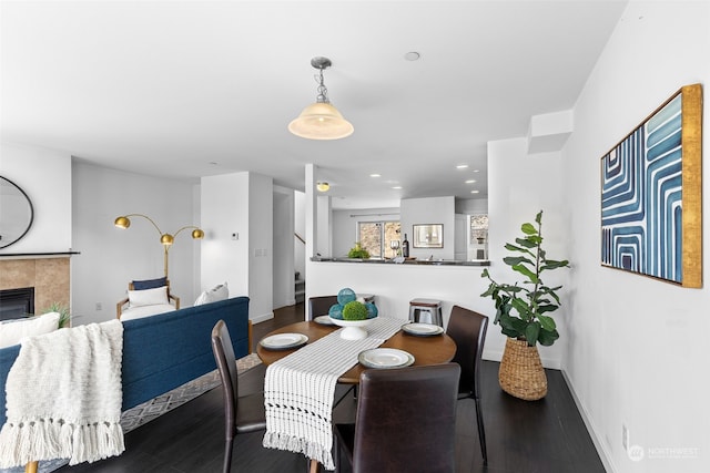 dining space with wood-type flooring and a fireplace