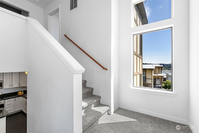 stairs featuring built in desk and carpet floors