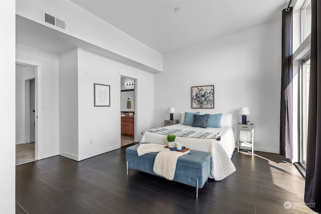 bedroom with hardwood / wood-style floors and ensuite bath