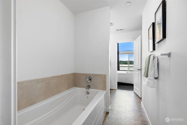 bathroom featuring tile patterned floors and tiled bath