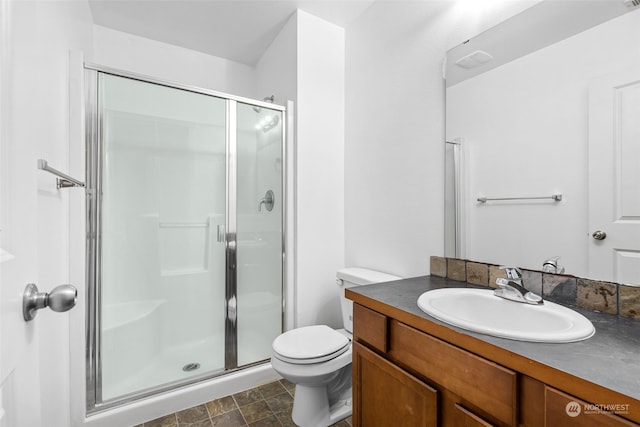 bathroom with toilet, tile patterned floors, vanity, and a shower with shower door