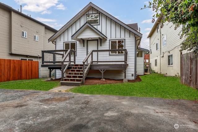 view of front of property with a wooden deck and a front yard