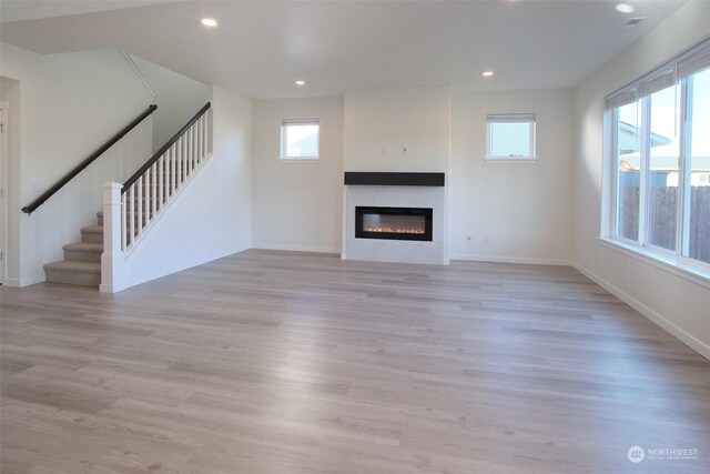 unfurnished living room with a wealth of natural light and light hardwood / wood-style flooring