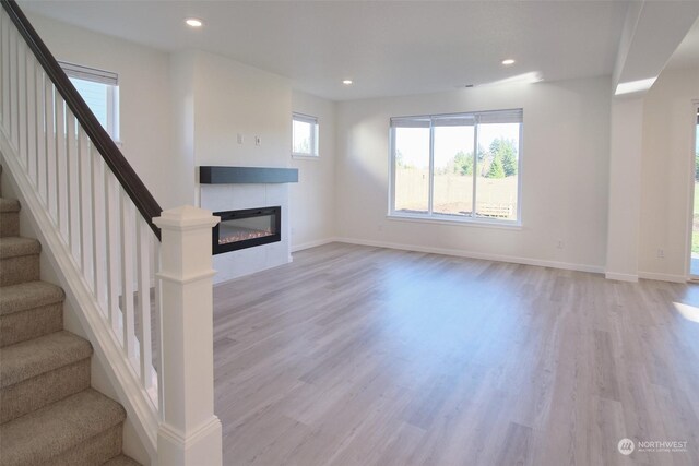 unfurnished living room with a fireplace and light hardwood / wood-style floors