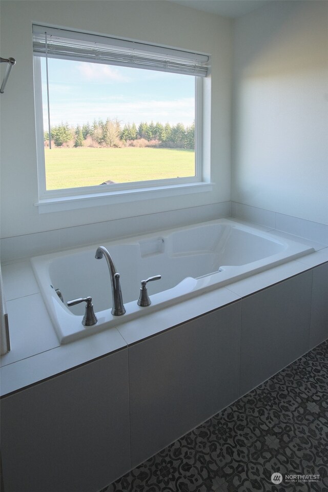 bathroom featuring a relaxing tiled tub and tile patterned floors