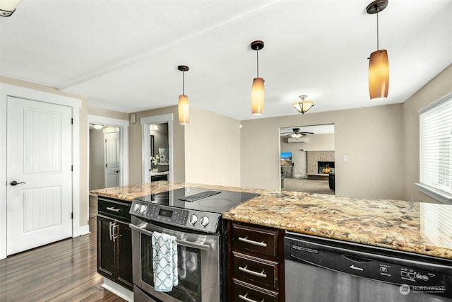 kitchen featuring light stone counters, appliances with stainless steel finishes, dark hardwood / wood-style floors, and hanging light fixtures