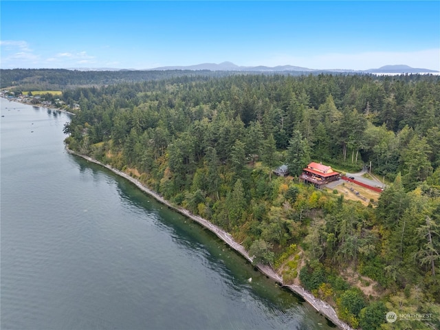 bird's eye view featuring a wooded view and a water and mountain view