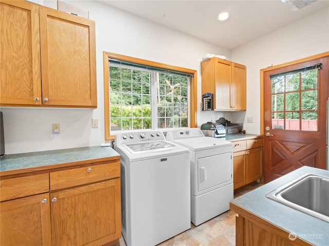 laundry area with a wealth of natural light, washer and clothes dryer, a sink, and cabinet space