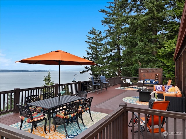 deck featuring outdoor dining space, outdoor lounge area, and a water view